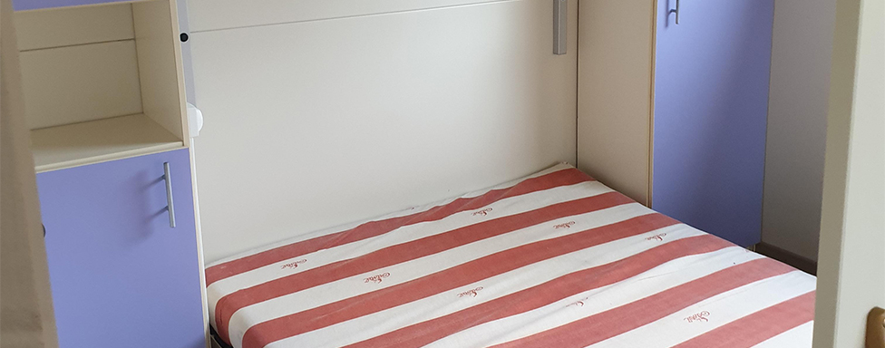 The bedroom with a double bed in the 5-person chalet, available for rent at The Léhan campsite in Brittany in Finistère, by the sea
