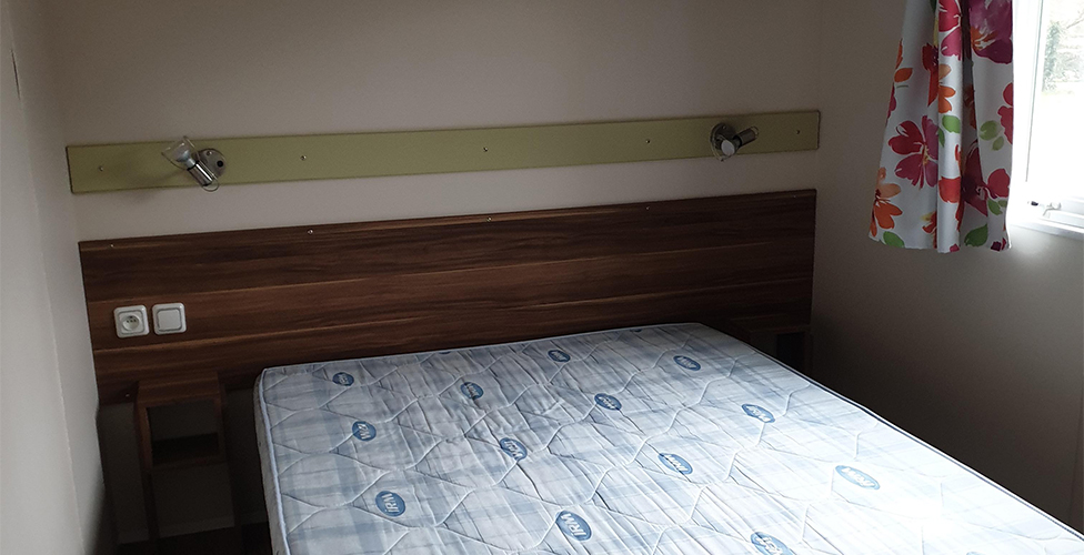 The bedroom with a double bed in the 4-person mobile home, available for rental at The Léhan campsite in Brittany, by the sea