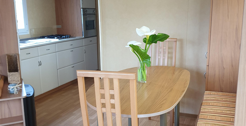 The equipped kitchenette and living room of the 6-person mobile home, available for rental at The Léhan campsite in Brittany in Treffiagat, by the sea