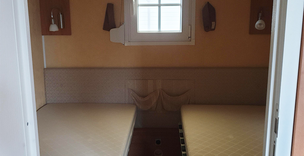 The bedroom with two single beds in the 6-person mobile home, available for rental at The Léhan campsite in Brittany in Treffiagat, by the sea